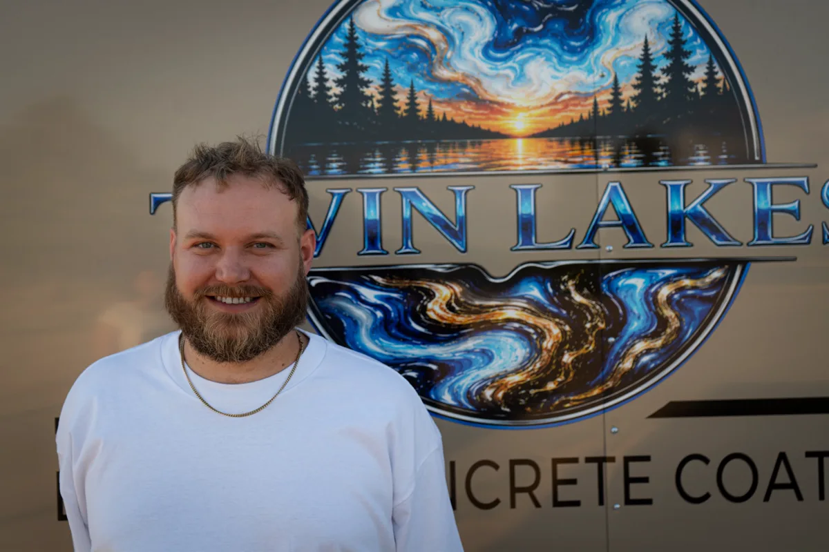 Houston Barlow, co-owner of Twin Lakes Epoxy, standing beside the company trailer wrap