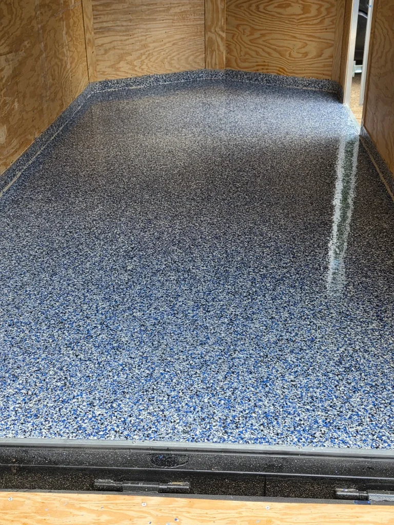 Twin Lakes Epoxy enclosed box trailer after installation of a blue-gray full-flake floor coating