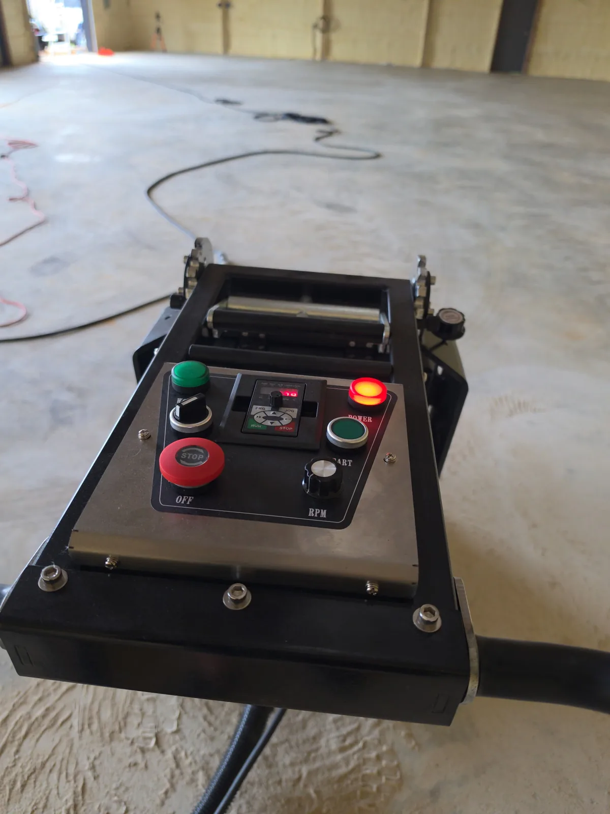 Floor grinder control panel on bare concrete in a large shop during surface preparation for epoxy flooring